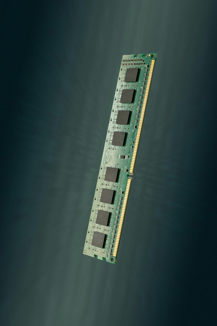Barrette de mémoire vive (RAM) montrant ses puces mémoire alignées sur le circuit imprimé vert et ses connecteurs dorés