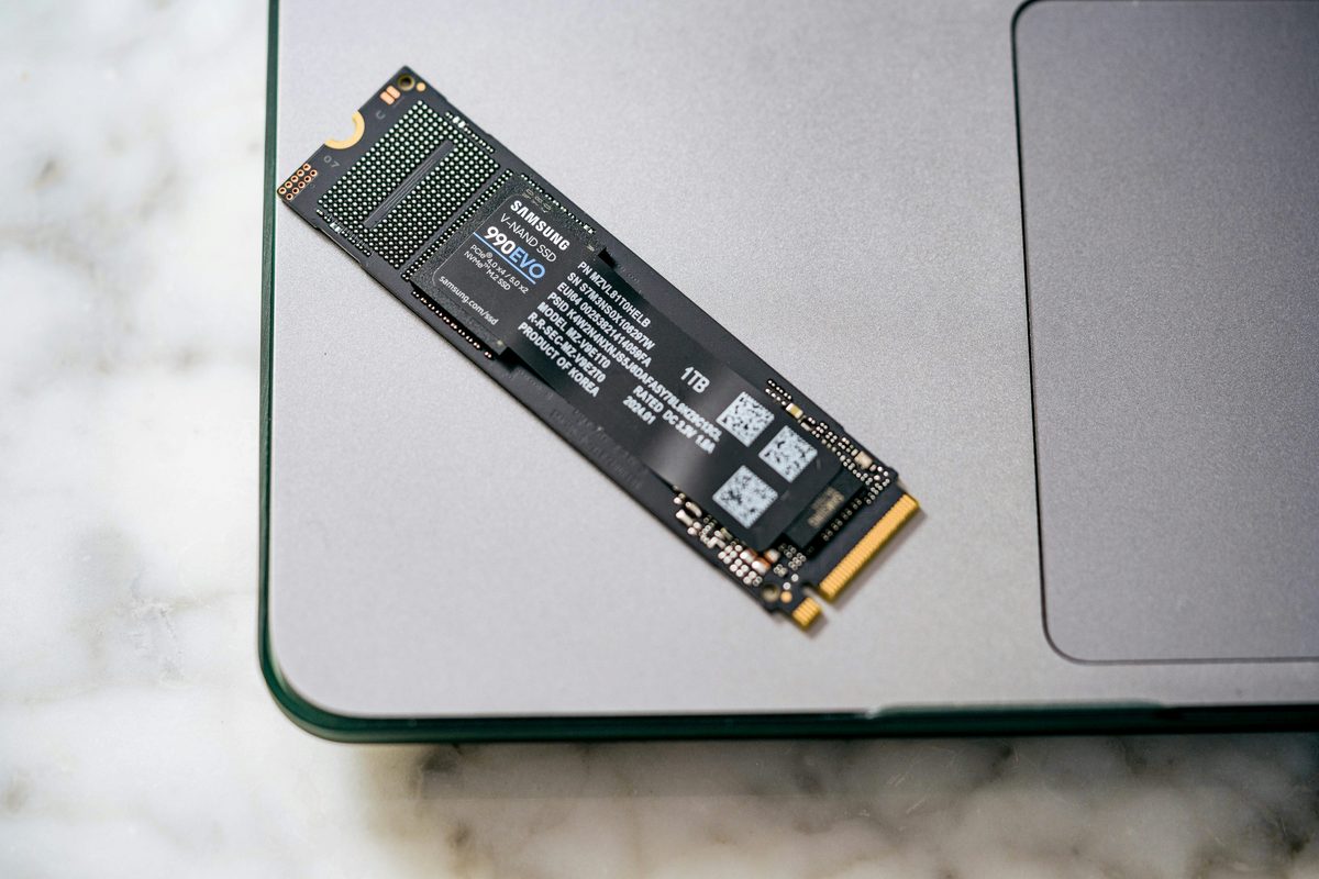 Disque SSD au format M.2 posé sur un ordinateur portable, montrant sa puce de mémoire flash et son étiquette